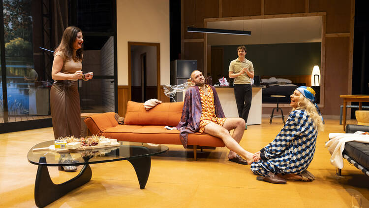 Four actors perform in a stage that resembles a lounge room.