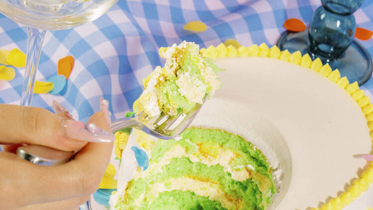 Someone taking a forkful of a green sponge layer cake. 
