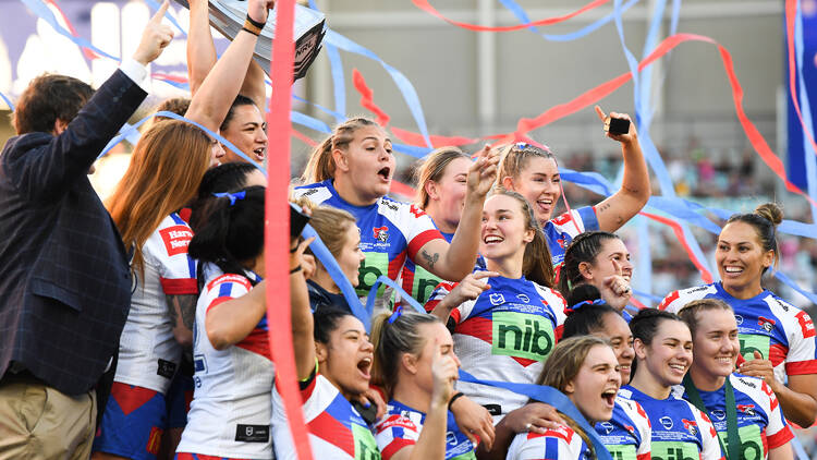 A team of women in red, white and blue sports jerseys, celebrating with streamers