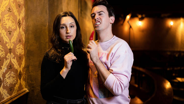 Two comedians pose with hot peppers.