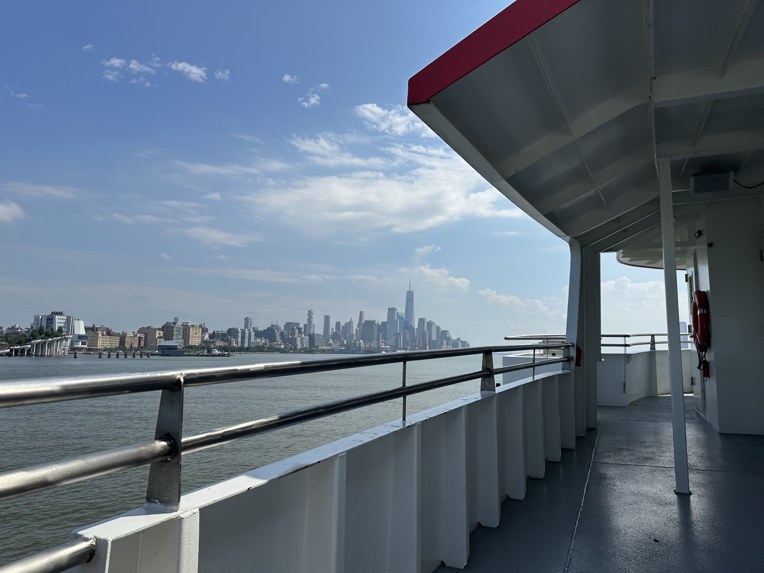 The roof deck of a Circle Line cruise with a view of Lower Manhattan in the background.