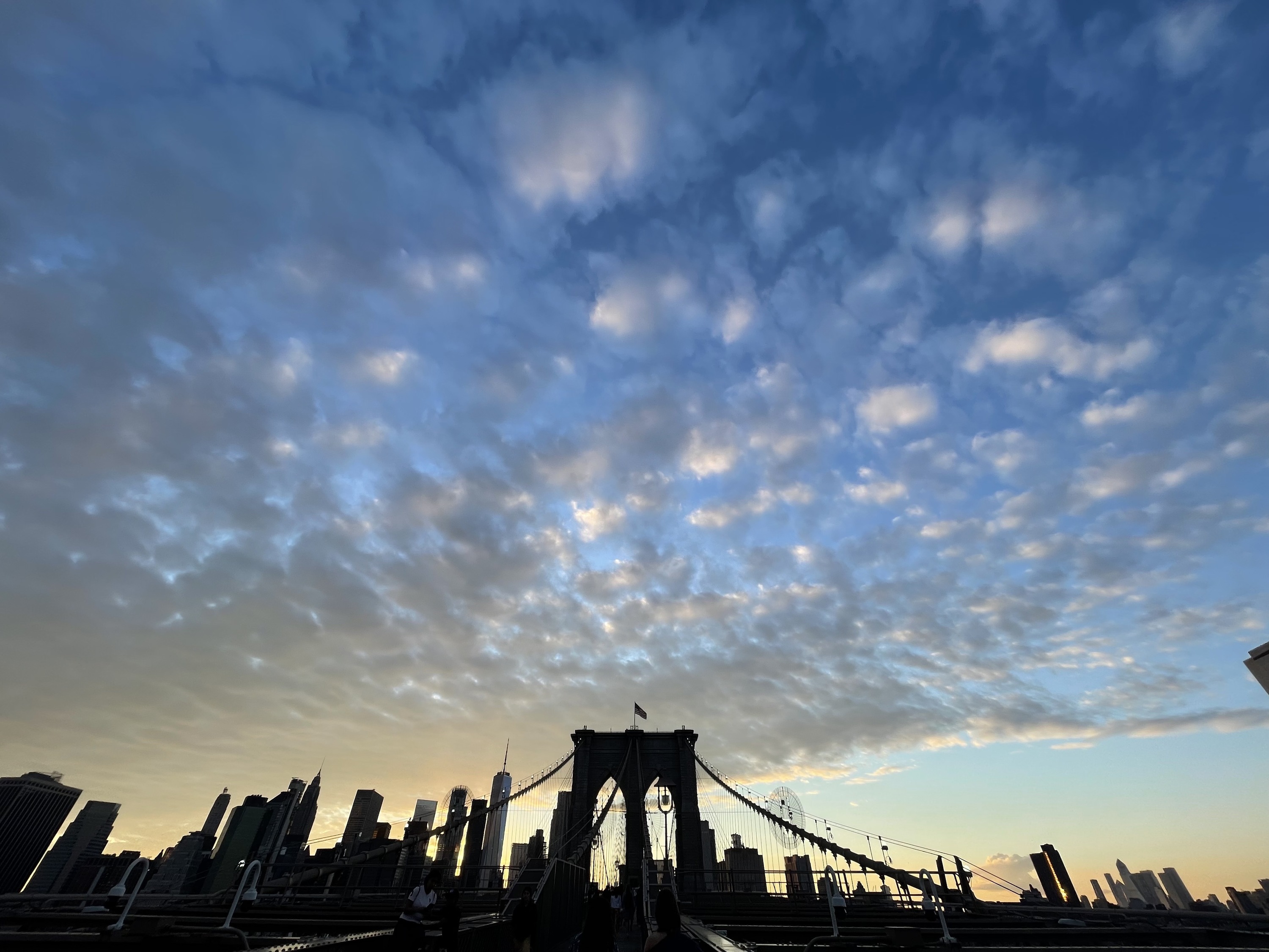 A cloudy sunset sky atop the Brooklyn Bridge.