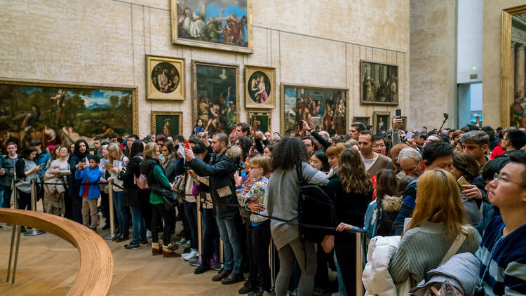 Visitors take photo of Leonardo da Vinci's Mona Lisa at the Louvre Museum