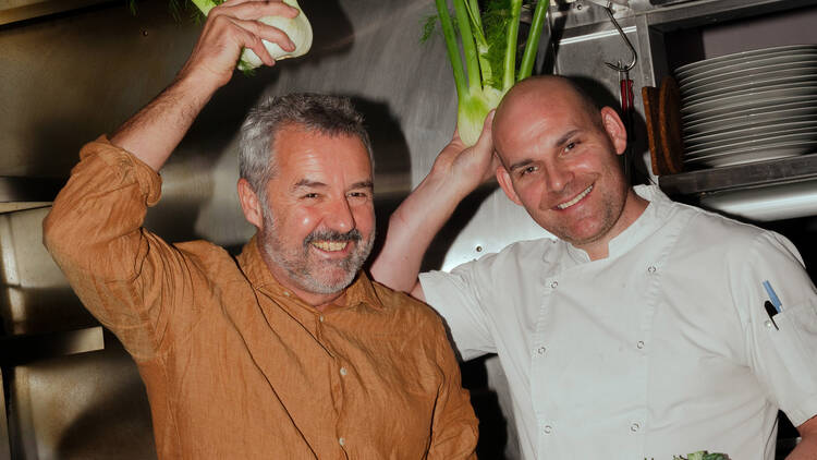 Smiling chefs cheekily posing with green vegetables. 