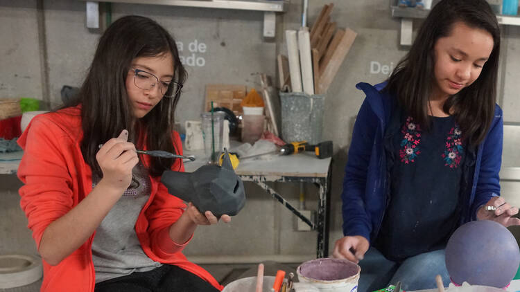 Curso de verano en CENTRO para niños. Niñas pintando cabeza de lobo