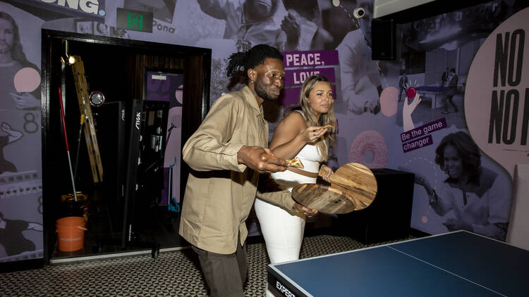 Two people playing ping pong. 