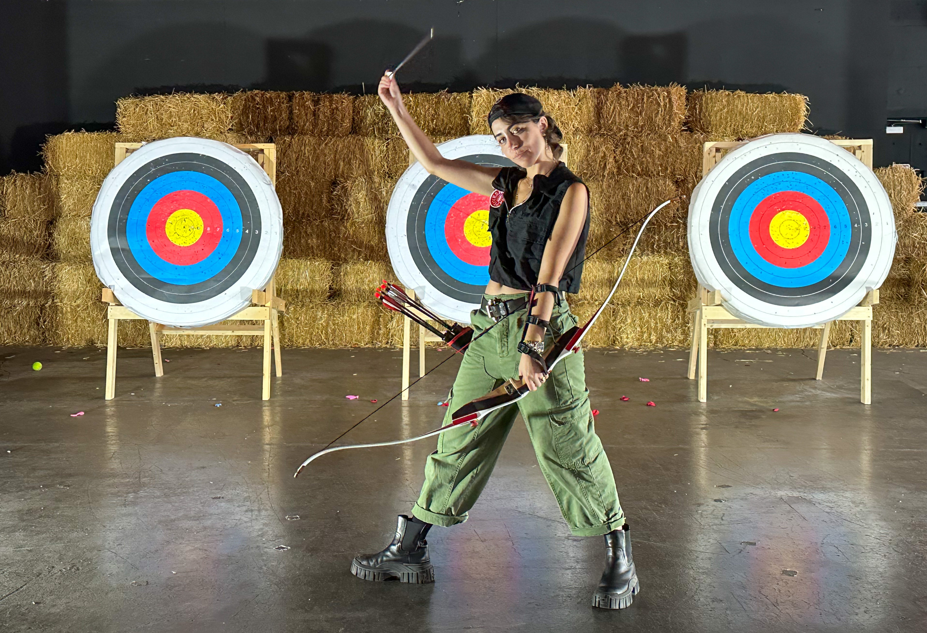 Kendall Tichner holds a bow and arrow inside Wild Captives studio. 