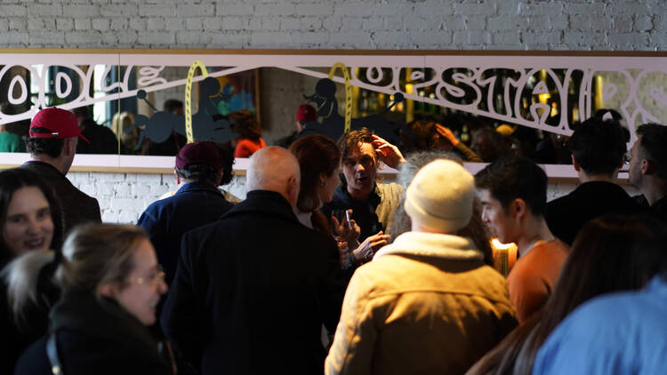 People gathering at Poodle's upstairs area for a wine tasting event.