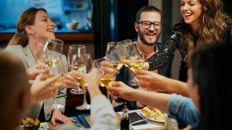 A group toasts glasses of white wine