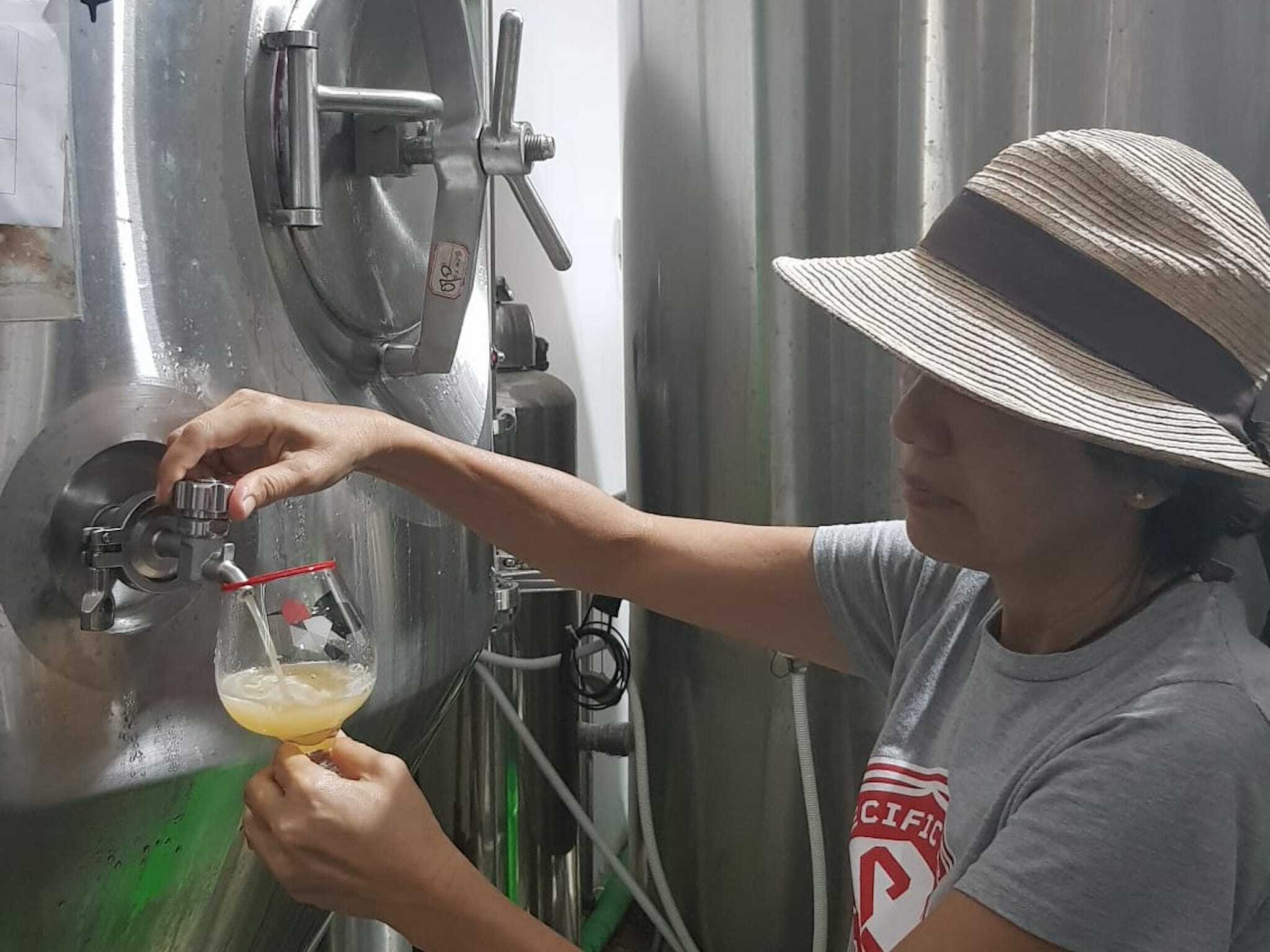 Brewer Kim Wong drawing beer from the tank
