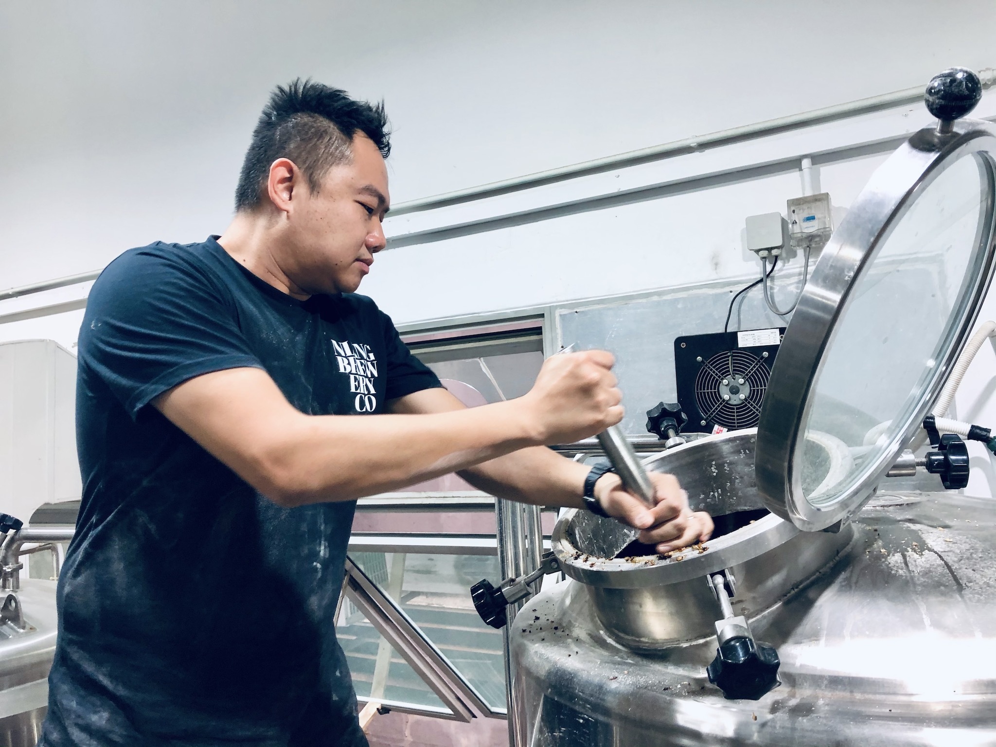Brewer Mark Chen working the mash tun