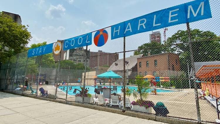 A pool in Harlem with a sign that says Stay Cool Harlem