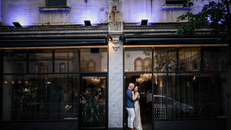 A couple on their wedding day stand in a doorway. 