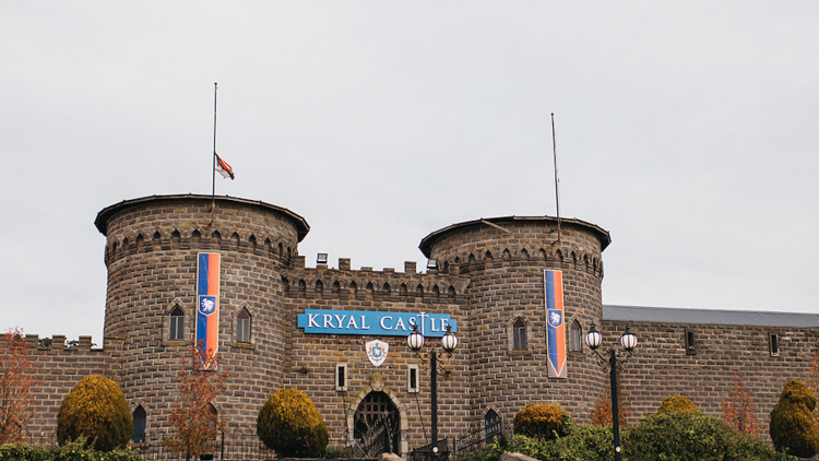 A stone castle with flags on the turrets. 