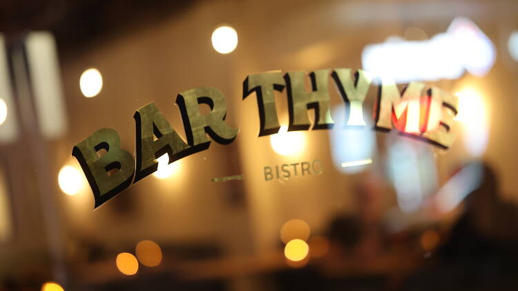 The 'Bar Thyme' bistro sign on a glass window.