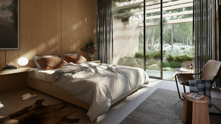 A hotel room with bed and a large window with sunlight streaming in. 