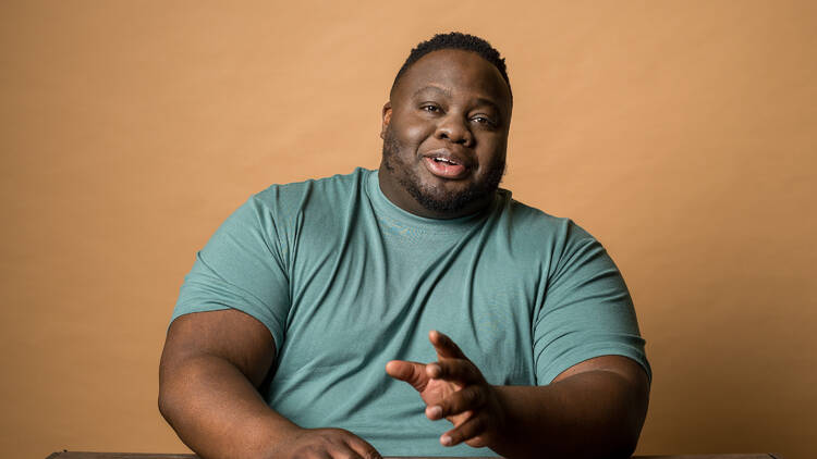 A person sitting in front of a yellow backdrop