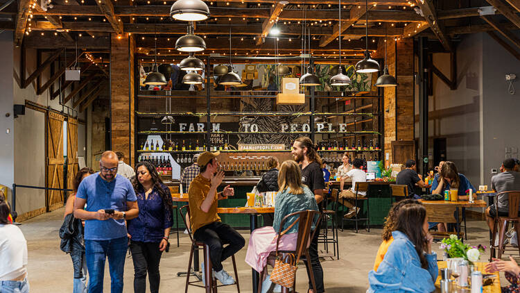 People sit at tables inside Farm to People restaurant.