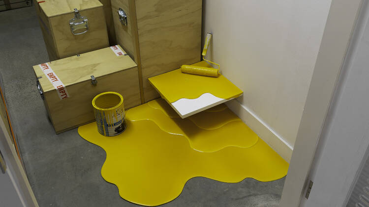 picture of yellow tub of paint spilt on the floor