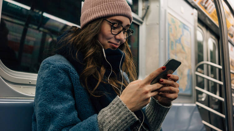 Woman using her cell phone on the subway