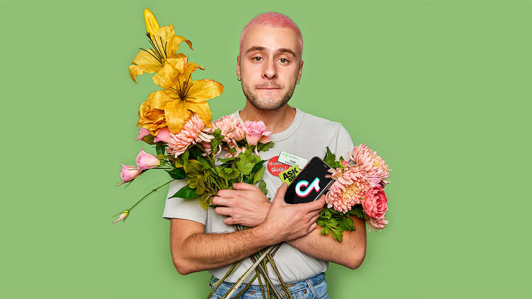 A man with pink hair holding flowers