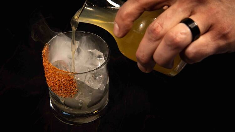 Cocktail being poured into a glass
