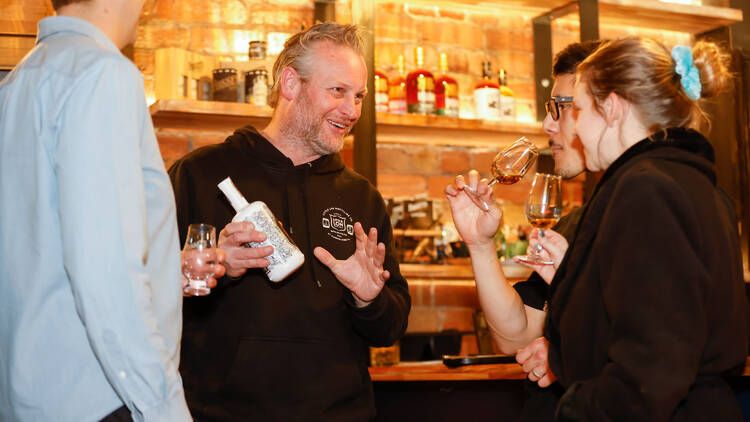 Whisky distiller chatting to participants during a tasting session.