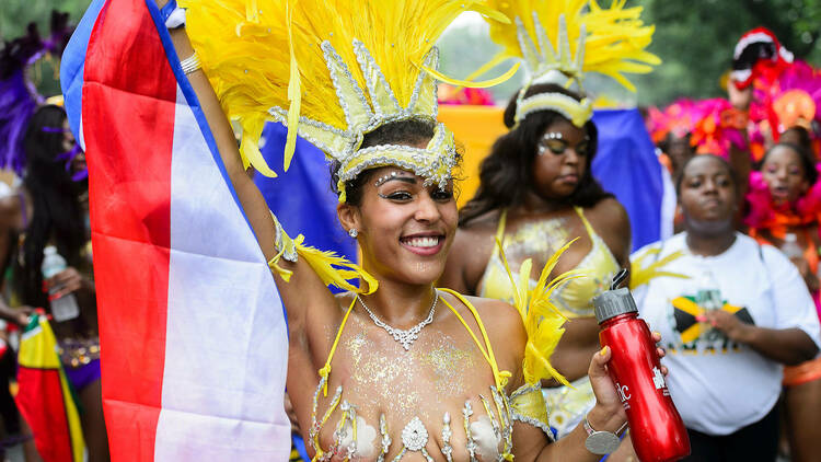 A woman in a yellow outfit at the West Indian parade.