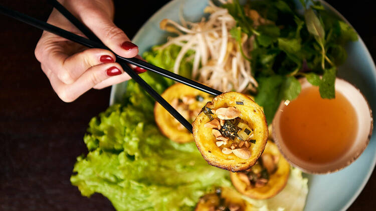 Diner eating Vietnamese food with chopsticks.
