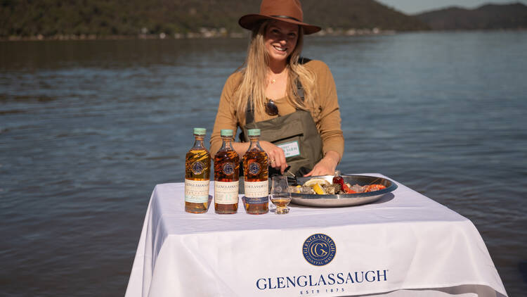 A woman enjoying whisky and seafood at the Glenglassaugh Whisky Immerse Yourself experience