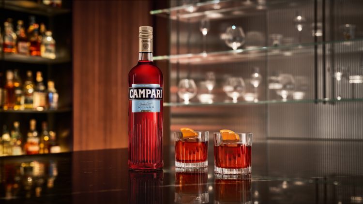 A Campari bottle next to two negronis