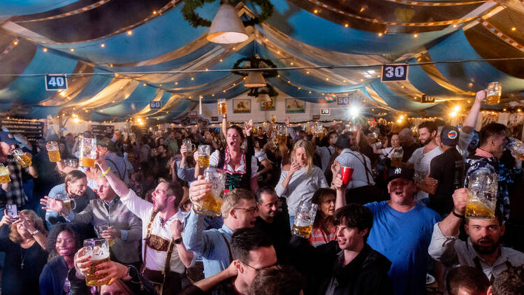 A tent packed with people celebrating Oktoberfest.