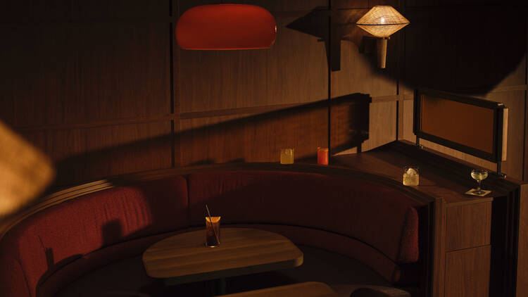 Dimly lit interior of Studio Amaro with lamps, tables and banquettes.