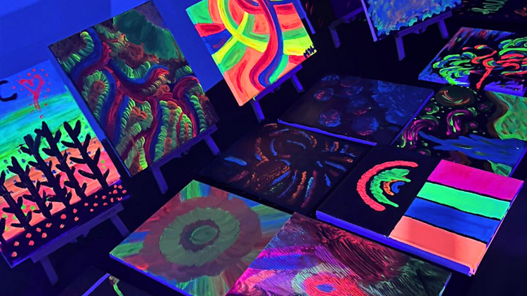 Canvases with neon artworks painted on them. 