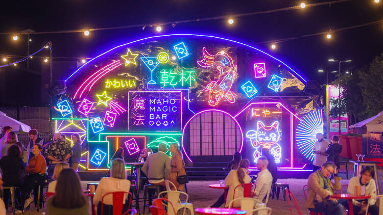 A neon-lit building covered in bright cartoons. 