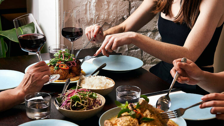 Assorted dishes of Vietnamese food and red wine.