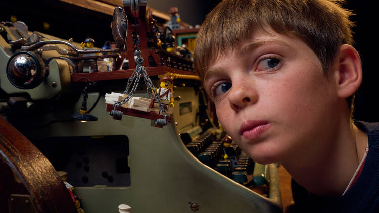 A child next to a lego creation inside a typewriter.
