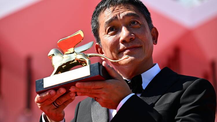Hong Kong actor Tony Leung Chiu-wai poses on the red carpet after being awarded with the Golden Lion for Lifetime Achievement award at the 80th Venice Film Festival on September 2, 2023 at Venice Lido