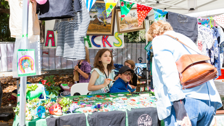 A kid running a crafty market stall