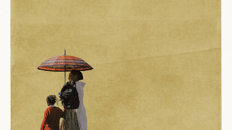 picture of a woman and a child holding an umbrella against a yellow background 