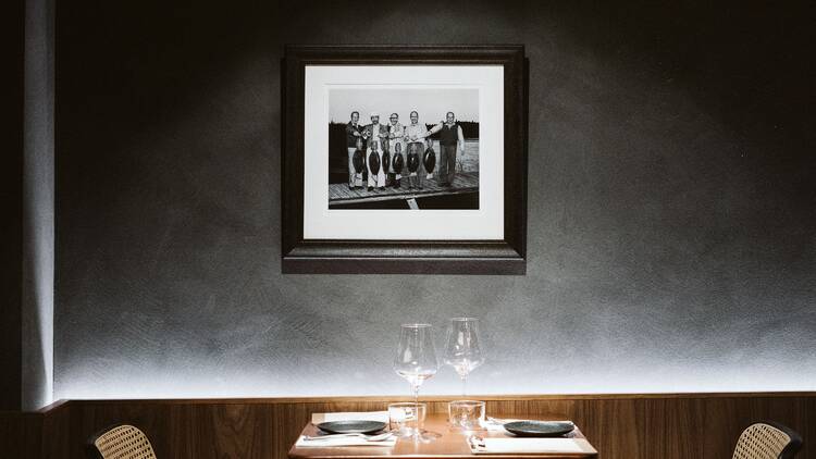 Dining table for two underneath a framed photograph.