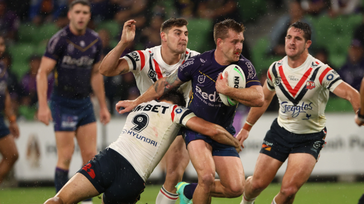 A Sydney Roosters player tackles a Melbourne Storm player during an NRL match.