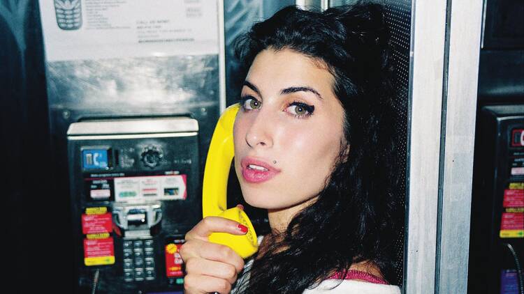 picture of amy winehouse holding up a yellow telephone