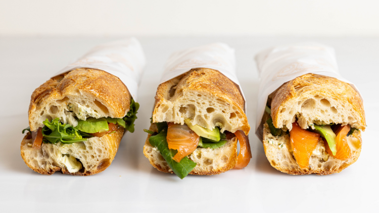 Row of salmon avocado baguette sandwiches