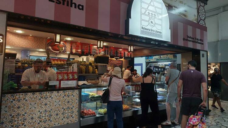 Pessoas na vitrine da Rotisseria Sírio Libaneza