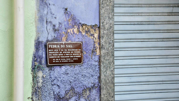 Placa com informações sobre a Pedra do Sal na parede