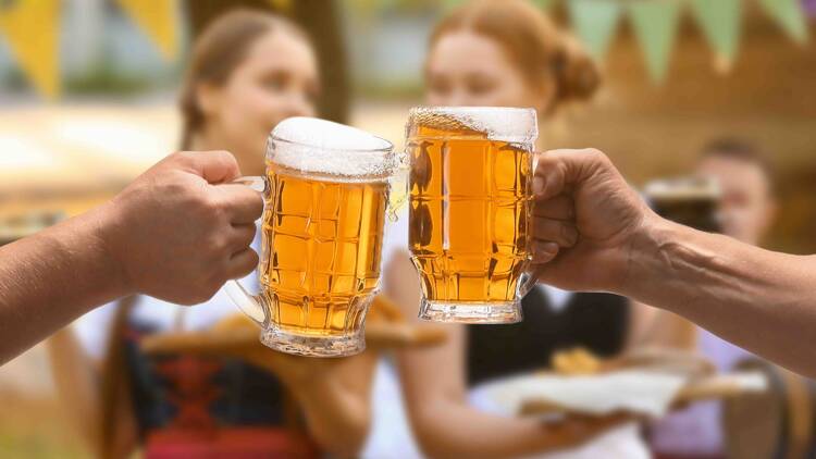 Two people cheersing with two glasses of beer