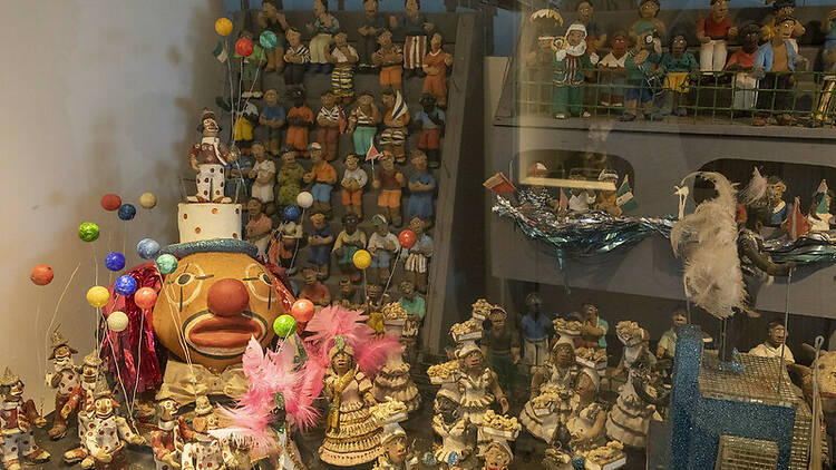 Vários bonequinhos de artesanato em uma vitrine