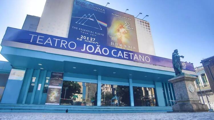 Fachada do Teatro João Caetano, toda em azul, com banner da peça em cartaz