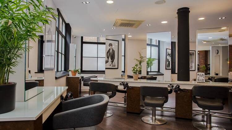 A salon with mirrors and hairdressing chairs